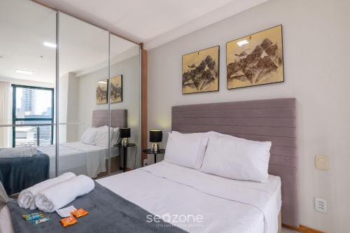 a bedroom with two beds and a mirror at Studio w/ pool & barbecue in the building RAQ1609 in Salvador