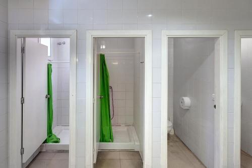 baño con ducha con cortina verde en Alberg Montsec-Mur, en Guardia de Tremp