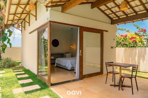 a room with a bed and a table with a table at Villa Kaitei in São Miguel do Gostoso