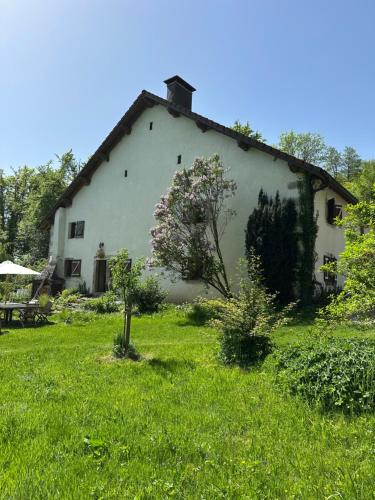 Tiny House La Tourelle في La Rosière: مبنى أبيض كبير ذو فناء عشبي