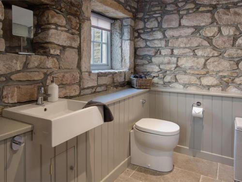 a stone bathroom with a sink and a toilet at 4 Bed in Bamburgh oc-cn089 in Bamburgh