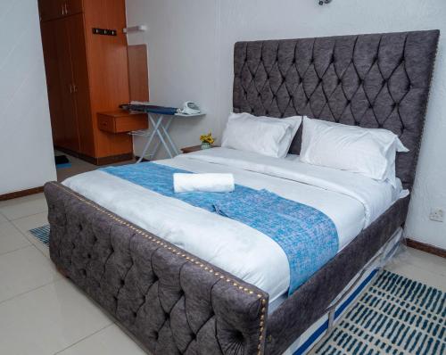 a large bed with a large headboard in a room at Perfect Palm Condos-P2 in Nakuru