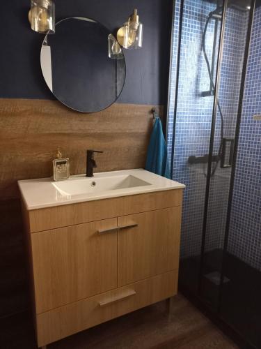 a bathroom with a sink and a shower with a mirror at Blue House - double bed in Almada