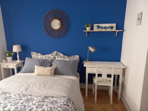 a blue bedroom with a bed and a table with a mirror at Blue House - double bed in Almada