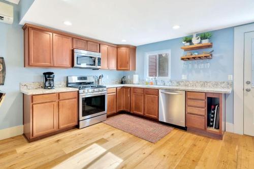 a kitchen with wooden cabinets and stainless steel appliances at Home Squared-Downtown with Fire Pit in Paso Robles