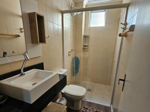 a bathroom with a sink and a toilet and a shower at Apartamento Beira-mar praia centro itapema in Itapema