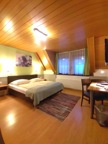 a bedroom with a large bed and a table at Hotel Smart-Inn in Erlangen