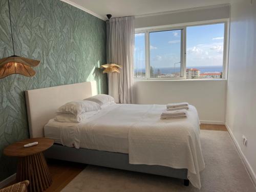 a bedroom with a bed and a large window at Toi et Moi Apartments-Guests speek for us! in Ponta Delgada