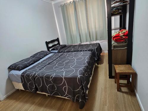 a small bedroom with a bed and a chair at Apartamento Beira-mar praia centro itapema in Itapema