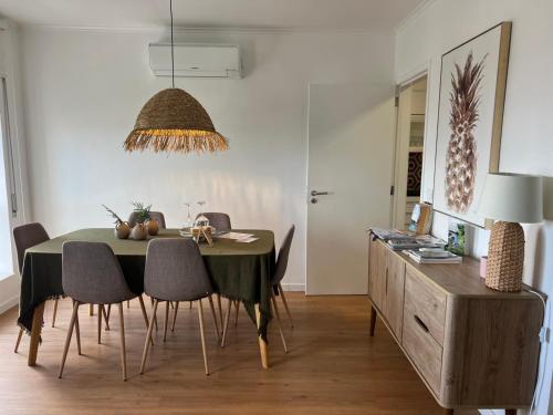 a dining room with a green table and chairs at Toi et Moi Apartments-Guests speek for us! in Ponta Delgada