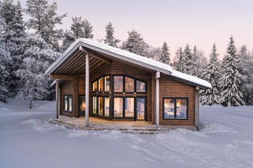 a log cabin in the snow with trees at Villa Vaellus in Ruka