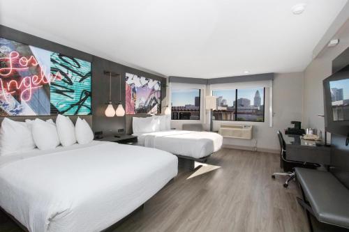 a hotel room with two beds and a desk at Aiden Los Angeles Downtown Dragon Gate Inn in Los Angeles