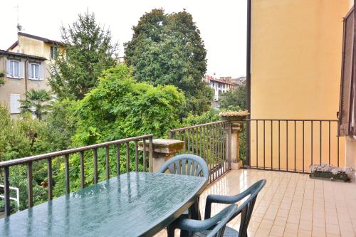 a green table and chairs on a balcony with a fence at Hotel Trentina in Milan