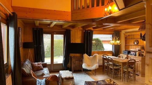 a living room with a table and a dining room at Red Fir Chalet in Megève