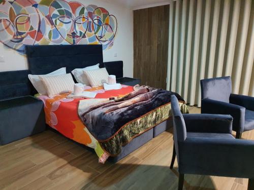 a bedroom with a large bed and two chairs at Gojim Casa Rural in Armamar