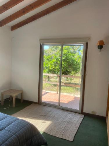 a bedroom with a large sliding glass door at Hermosa Cabaña en Limache in Lo Narváez