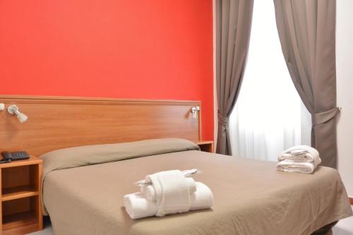 a hotel room with a bed with towels on it at Hotel Trentina in Milan