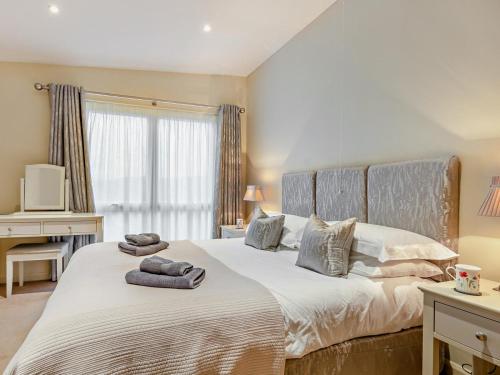 a bedroom with a large bed with towels on it at 4 Bed in Windermere oc-95682 in Winster