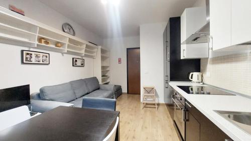 a kitchen and living room with a couch in a room at Palazzo Piccolo in Cave del Predil