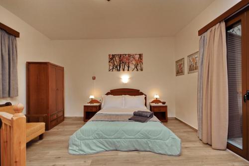 a bedroom with a large bed and two night stands at Valtessiniko Studios in Valtessiniko