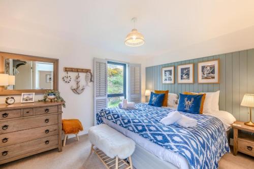 a bedroom with a blue and white bed and a dresser at 3 Bed in Bamburgh oc-r30372 in Bamburgh