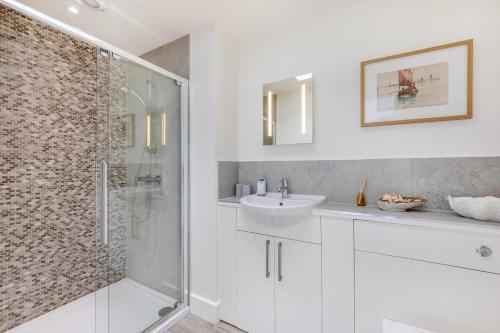 a white bathroom with a sink and a shower at 3 Bed in Bamburgh oc-r30372 in Bamburgh