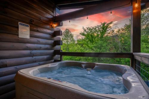 a jacuzzi tub on a deck with a view at Afterglow by Ghosal Luxury Lodging in Sevierville
