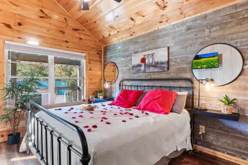 a bedroom with a bed with red pillows at Afterglow by Ghosal Luxury Lodging in Sevierville