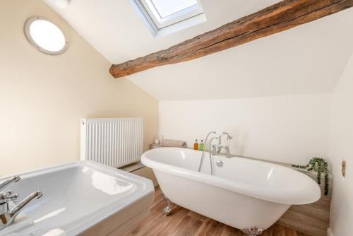 a white bath tub in a bathroom with a skylight at 2 Bed in Caldbeck oc-a32049 in Caldbeck