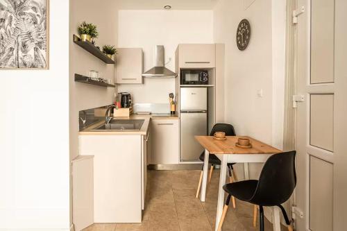 a small kitchen with a wooden table and chairs at Studio narbonne in Narbonne