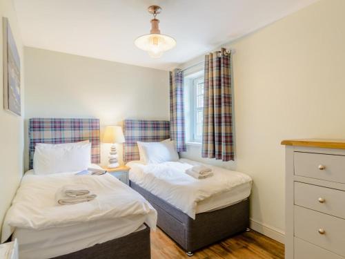 a bedroom with two beds and a window at 3 Bed in Chathill oc-79566 in Beadnell