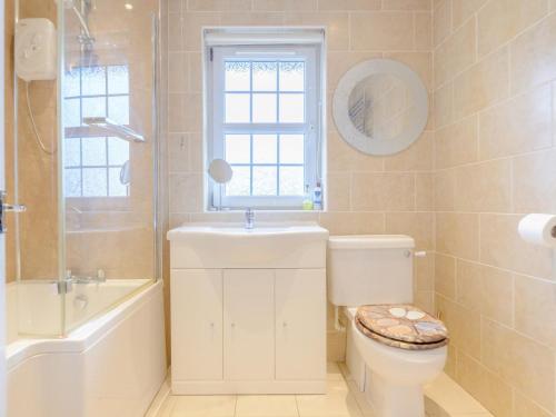 a bathroom with a toilet and a sink and a window at 3 Bed in Chathill oc-79566 in Beadnell
