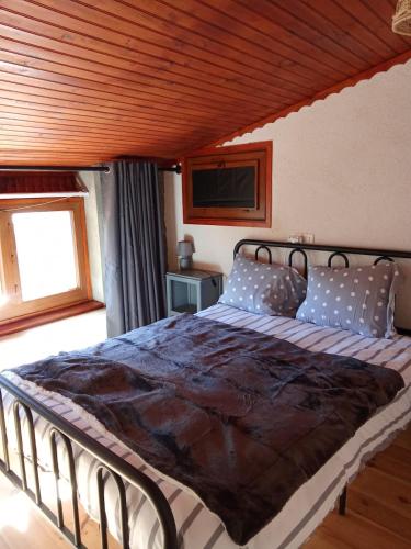 a bedroom with a large bed with a wooden ceiling at La maison du meunier in Olette