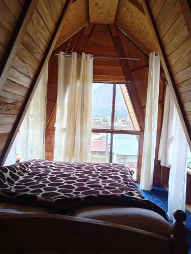 a bed in a room with a large window at Casa de campo y Chalet las Morenas in Sicuani