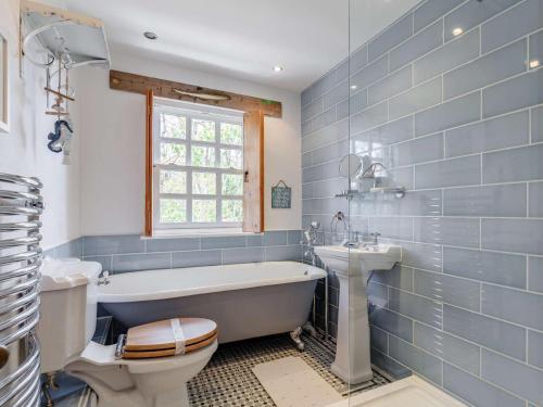 a bathroom with a tub and a toilet and a sink at 2 Bed in Wadebridge oc-82682 in Little Petherick