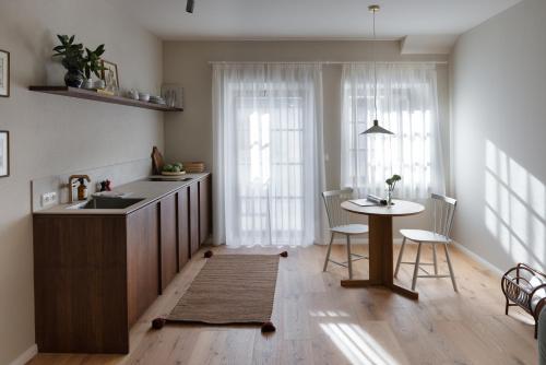 a kitchen with a sink and a table with chairs at Karls Mittenwald - Design Apartments mit Alpenblick & Tagesbar im Herzen von Mittenwald in Mittenwald