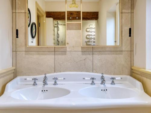 a bathroom with a white sink and a mirror at 5 Bed in Choseley oc-kt086 in Titchwell
