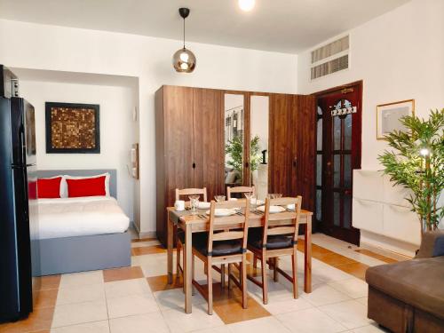 a living room with a dining room table and a bed at One Guest Place Deluxe Room near the Beach in Abu Dhabi