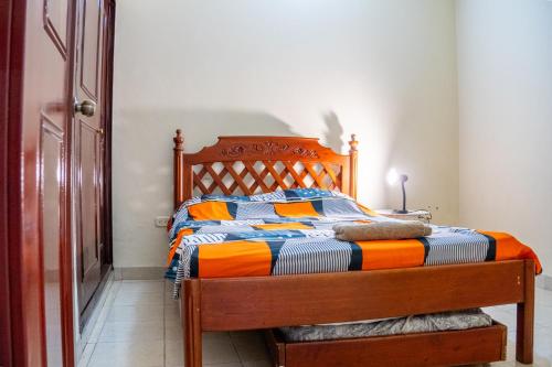 a bedroom with a bed with an orange and blue comforter at Piazza Granada in Cali