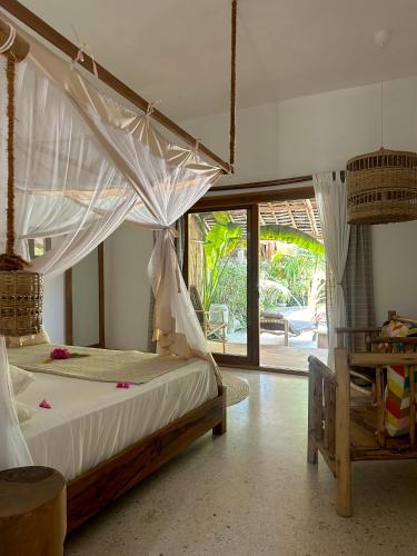 a bedroom with a bed with a mosquito net at Boutique Villa Unaweza in Matemwe