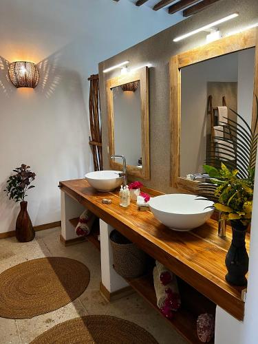 a bathroom with two sinks and a mirror at Boutique Villa Unaweza in Matemwe