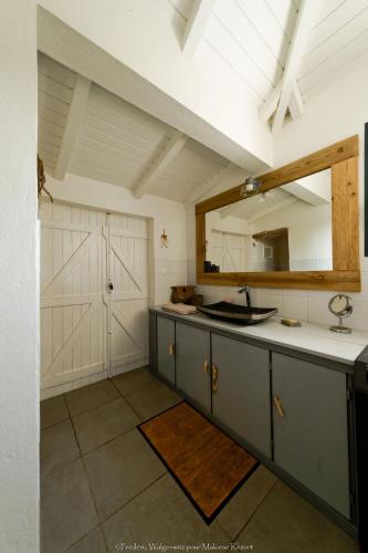a kitchen with a counter with a mirror and a sink at Makiese Resort in Saint-François