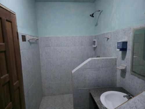ein Badezimmer mit Waschbecken und Dusche in der Unterkunft Hotel Nueva Alianza in Frontera Corozal