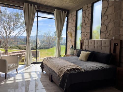 a bedroom with a large bed and large windows at Dos Aguas Hotel Boutique in Encinillas