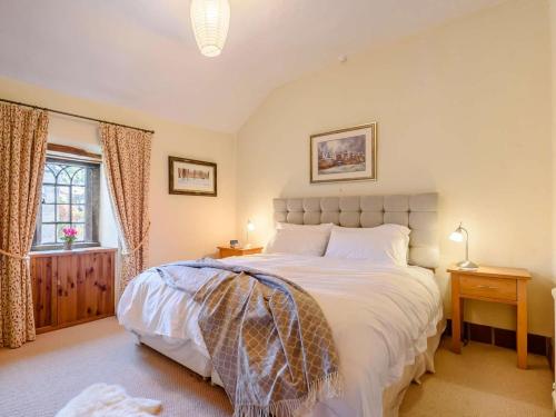 a bedroom with a large bed and a window at 2 Bed in Matlock oc-pk885 in Winster