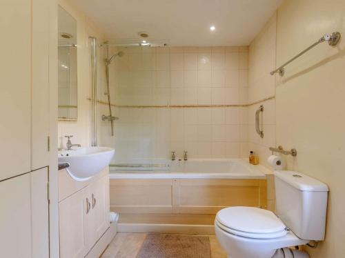 a bathroom with a tub and a toilet and a sink at 2 Bed in Matlock oc-pk885 in Winster