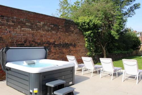 a hot tub and chairs on a patio at Our House Collective - Luxury Stay in Lincoln City Centre, Hot tub, Sleeps 16 in Lincoln