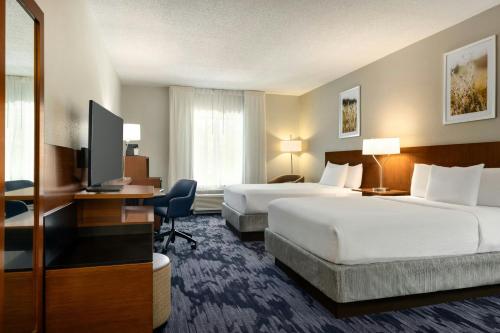 a hotel room with two beds and a flat screen tv at Fairfield Inn & Suites Savannah I-95 South in Savannah