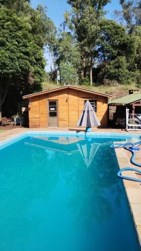 a house with a swimming pool and a building at Hospedaje Cabaña Completa in Rivera