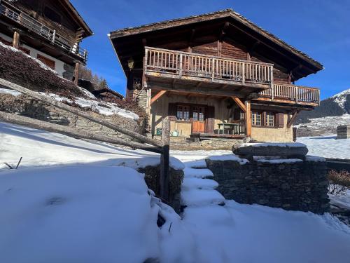a log cabin in the snow with a pile of snow at Chalet Le Zirizui - Authentique refuge alpin avec vue imprenable in Liddes